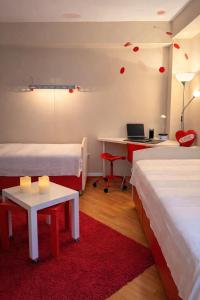 a room with two beds and a desk with a laptop at Sim apartment in Skopje in Skopje