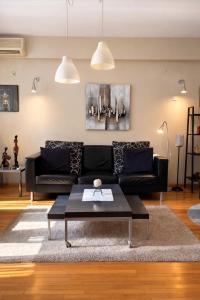 a living room with a black couch and a coffee table at Sim apartment in Skopje in Skopje +4 photos