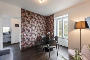 a living room with a dining room table with a floral wallpaper at Rapallo - Monolocale con piscina in Rapallo