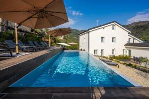 a swimming pool with umbrellas next to a building at Rapallo - Monolocale con piscina in Rapallo