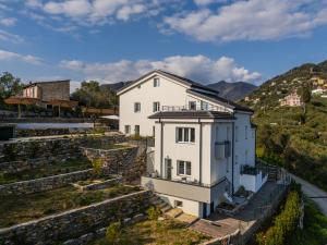 a white house with a hill in the background at Rapallo - Monolocale con piscina in Rapallo
