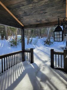 a porch of a cabin with snow on the ground at Cold Brook Lodge - 2 and 3 Bedroom Luxury Apartments in Lake Placid