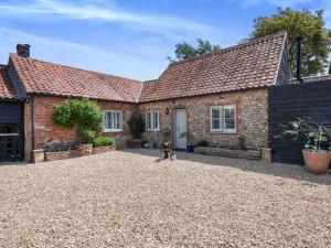 a dog sitting in front of a brick house at 3 Bed in Kings Lynn oc-88223 in Beeston