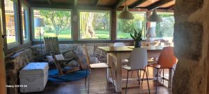a dining room with a table and chairs and windows at Os Salguieiros (the Willows) in Pontevedra