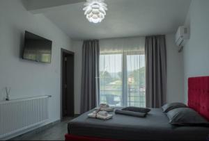 a bedroom with a bed and a large window at Mala House in Orşova +20 photos