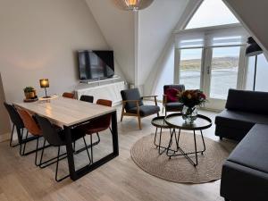 a living room with a wooden table and chairs at Residence Le Mistral in Noordwijk aan Zee