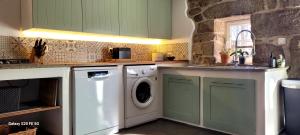a kitchen with green cabinets and a washer and dryer at Os Salguieiros (the Willows) in Pontevedra