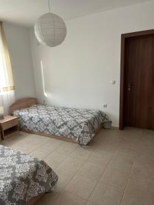 a bedroom with two beds and a light fixture at Villa Campo in Ezerets