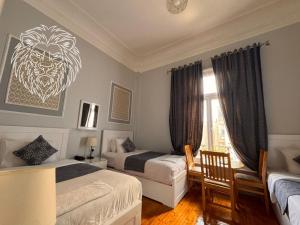 a bedroom with two beds and a lion picture on the wall at colombia inn cairo in Cairo