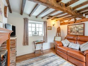 a living room with a leather couch and a fireplace at 1 Bed in Gainsborough oc-66230 in Heapham