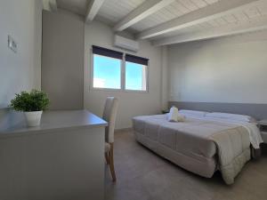 a bedroom with a bed and a desk and a window at Salionze Apartments in Salionze