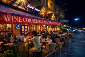 a group of people sitting at a wine corner bar and restaurant at Ban Ao Thong in Trang