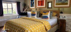 a bedroom with a bed with a yellow and white blanket at Os Salguieiros (the Willows) in Pontevedra