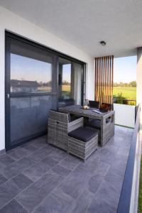 an outdoor patio with a table and wicker chairs at White Mountain Apartment in Banovci