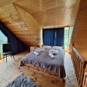 a bedroom with a large bed in a wooden room at Cliffside - ქლიფსაიდი in Makhunts'et'i