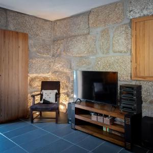 a living room with a tv and a chair at WABI SABI-QuintAlão in Passô