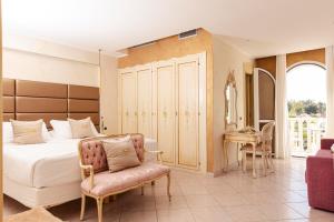 a bedroom with a bed and a chair and a table at Fiordaliso Hotel in San Felice Circeo