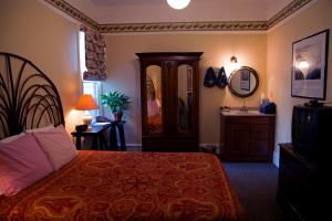 a bedroom with a bed and a dresser and a mirror at The Willows Inn in San Francisco