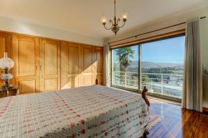 a bedroom with a bed and a large window at Lagos House in Braga +34 photos