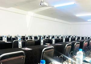 a conference room with black tables and chairs and bottles of water at Mika Lodge in Lusaka +40 photos