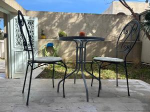 two chairs and a table in front of a house at Work and Wave cosy studio at La Marsa in Douar el Hafey