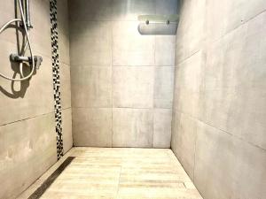 a bathroom with a shower with a tile floor at Work and Wave cosy studio at La Marsa in Douar el Hafey