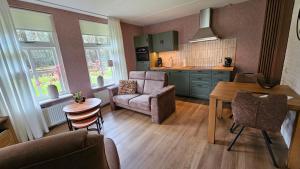 a kitchen and living room with a table and chairs at B & B de Vlegge in Sibculo