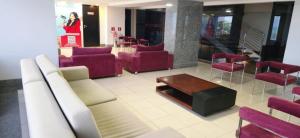 a waiting room with red chairs and a table at Apartamento Vista Mar Belli Golden tower in Natal