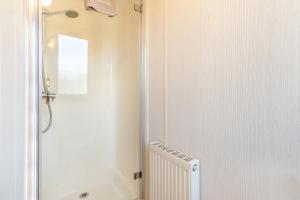 a bathroom with a shower and a sink and a toilet at Athelington lodge - Beech in Eye +28 photos