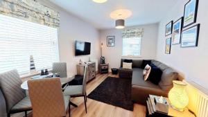 a living room with a couch and a table at The Puffin Pad - Part of the The Bay Filey Holiday Village with pool, gym and direct beach access, pub, restaurant, tennis and meadows walks in Filey