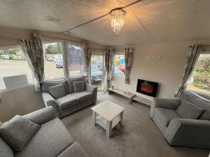a living room with couches and a fire place at Caravan 607 in Clacton-on-Sea