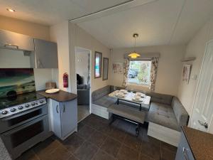 a kitchen with a couch and a table in it at Caravan 607 in Clacton-on-Sea