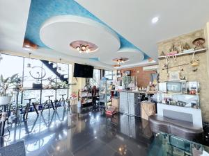a restaurant with a bar with a blue ceiling at เมืองเพ็ชร์ เกสต์เฮ้าส์ in Phetchaburi