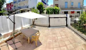 a white table and chairs and an umbrella on a balcony at Casa Vacanza Regina in Scalea
