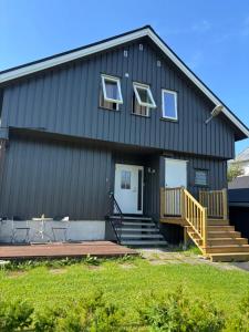 a black house with a porch and a deck at 4-Bedroom Accommodation Near NTNU & Raufoss Business Area in Gjøvik