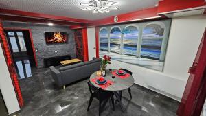 a living room with a table and a couch at La Suite Rouge Proche Paris & Stade De France in Drancy