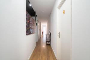 a hallway with white walls and a wooden floor at Hostal Sant Antoni in Barcelona