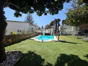 a pool with a person laying next to a umbrella at Villa puerto marina beach in Benalmádena