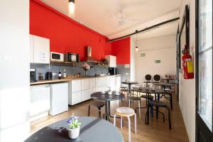 a kitchen with tables and a red wall at Hostal Sant Antoni in Barcelona