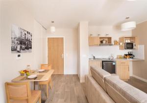 a living room and kitchen with a couch and a table at Zenao Appart'hôtels Montreuil in Montreuil +5 photos