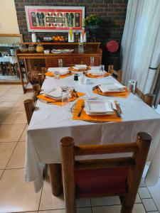 a table with a white table cloth and orange napkins at Lalakamnandi Guesthouse in Pretoria