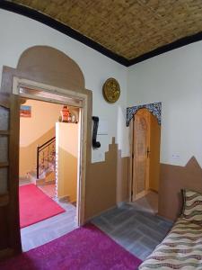 a room with a bed and a hallway with two doors at Dar Bani in Zagora