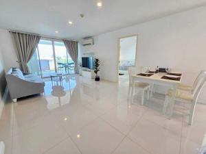 a large white living room with a table and chairs at 1 Bedroom Beachside Condo in Cha-am in Ban Bang Sai Yoi (1)