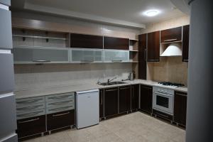a kitchen with brown cabinets and white appliances at Hotel Nicholas in Chişinău
