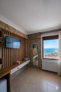 a living room with a large window and a television at Gokyuzu Hotel in Edremit +37 photos