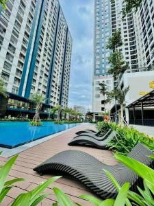 a pool in the middle of a city with tall buildings at Healing Home - Charm Ruby Apartment in Dĩ An