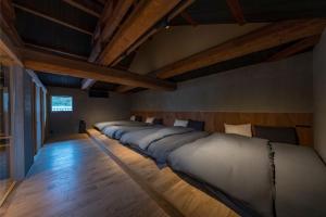 a row of beds in a room with wooden floors at Nui in Minamiawaji