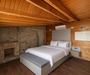 a bedroom with a large white bed and wooden walls at Gokyuzu Hotel in Edremit