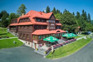 a large brown building with a red roof at Hotel Bouda Jana in Pec pod Sněžkou