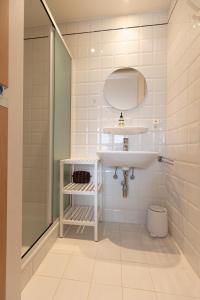 a white bathroom with a sink and a shower at Villa Castelli 52 Groenendijk in Nieuwpoort +28 photos
